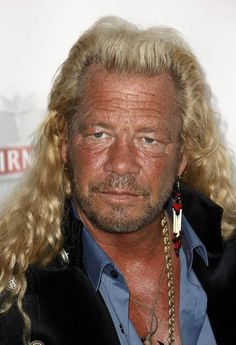 a man with long blonde hair wearing a black jacket