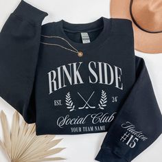 a black sweatshirt with the words pink side on it next to a hat and palm leaf