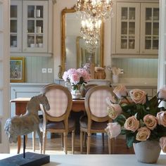 a dining room table with pink roses in the center