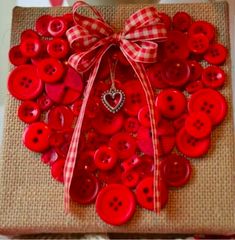 a red heart shaped box with buttons attached to it