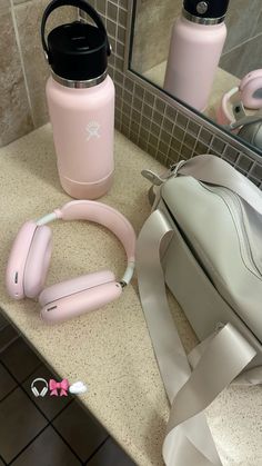 a pink backpack and headphones sitting on a bathroom counter