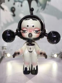 a creepy doll with black and white decorations on it's head is standing in front of a wall