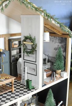 a doll house with christmas decorations on the top floor and furniture in the bottom half