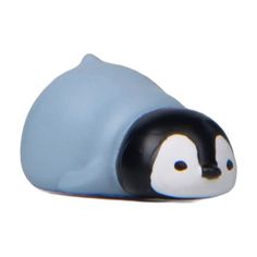 a small penguin figurine sitting on top of a white surface