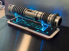 an electronic device is sitting on top of a metal surface with blue light coming from it