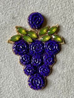 a brooch with grapes and leaves on it