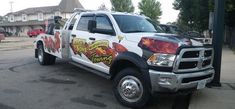 a large white truck with flames painted on it's side in a parking lot