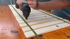 a person is using a drill to attach wood planks