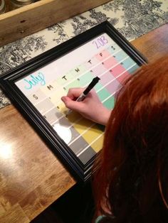 a person writing on a calendar with a marker