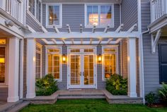 an outside view of a two story house with white trim and windows on both sides