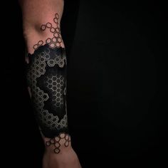 a man's arm covered in black and white tattoos