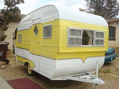 a yellow and white trailer parked in front of a house