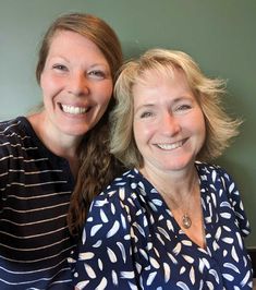 two women sitting next to each other smiling