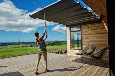 a woman holding onto an umbrella while standing on a deck