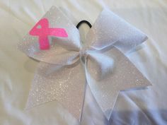 a pink and white bow on top of a bed