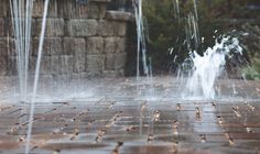 water spewing out from the top of a brick wall