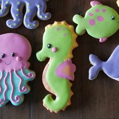 decorated cookies with sea animals on them sitting on a wooden table next to each other