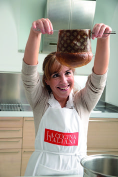 a woman in an apron holding up a jar with food on top of her head