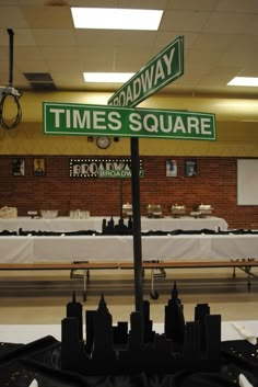 there is a street sign that says broadway and times square in front of tables with white tablecloths