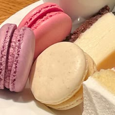 a plate topped with macaroons, cheese and other desserts next to a cup of coffee