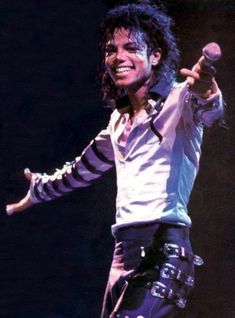 michael jackson performing on stage with his arms out in the air and holding a microphone