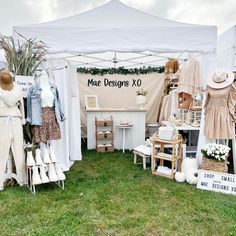 a tent with clothes on display in the grass