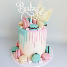 a baby shower cake with macaroons and cookies on it