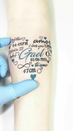 a person with blue gloves on their hands holding up a tattoo that has words and hearts all over it