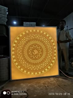 a man standing next to a large illuminated sign in a room with other men around it