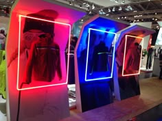 three mannequins with neon lights in front of them on display at an event