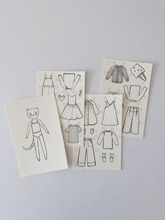 four cards with drawings of children's clothes on them, one has a cat and the other has a dress