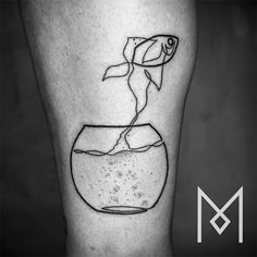 a black and white photo of a goldfish in a fish bowl tattoo on the leg