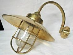 an antique brass wall light on a white sheeted background with the bulb turned off