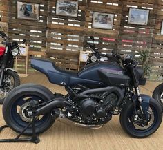 two motorcycles parked next to each other in front of wooden pallets with pictures on them