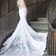 a woman in a wedding dress is standing on the stairs with her back to the camera