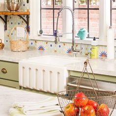 a basket of fruit sitting on top of a kitchen counter next to a sink and window