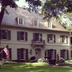 a large white house with an american flag in the front yard