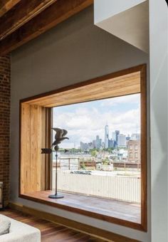 an open window in a living room with a view of the city skyline outside it