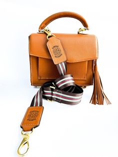 The Striped 1.5" Detachable Bag Strap is a stylish and versatile accessory designed to elevate the look of any handbag. Key features: Customization: The strap comes in two colors, allowing you to choose the one that best complements your purse. Premium Quality: Made from Epsom leather and colorful webbing, the strap is durable and resistant to damage. Gold Hardware: The gold metal hardware adds a touch of luxury and reinforces the strap's durability. Vibrant Colors: The strap's eye-catching colors and patterns will make your purse stand out. Easy Attachment: The strap is easy to attach and detach, making it convenient to use. Specifications: Size: 2 inches thick, adjustable from 38 to 52 inches. Material: Epsom Leather, Colorful Webbing 2" Striped, Poly Webbing Purse Strap Finished with le Oxford Ms, Striped Bags, Blue Handbags, Handmade Gift Wrap, Purse Strap, Handbag Straps, Guitar Strap, Bag Handle, Metal Hardware