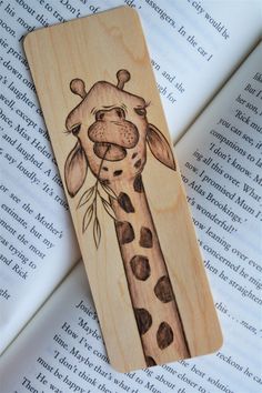 a wooden bookmark with a drawing of a giraffe's head on it