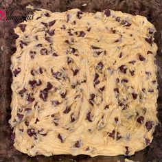 an uncooked cookie dough with raisins on it in a baking pan