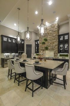 a large kitchen with black cabinets and white chairs