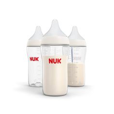 three baby bottles with the names nuk in red and white on them, next to each other