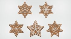 four cookies decorated with icing and snowflakes are arranged in the shape of stars