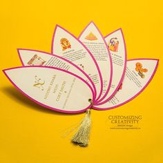 four cards with tassels on them sitting on a yellow surface