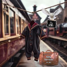 an owl is hanging on a clothes line next to a bag and train tracks, with a baby harry sweater hanging from the rail