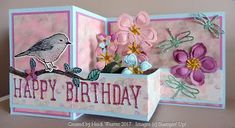 a birthday card with flowers and a bird on the branch in pink, purple and white