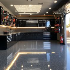 an empty garage with black cabinets and yellow lights on the ceiling is lit by recessed lighting