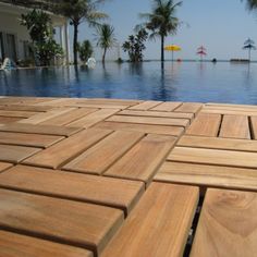 a wooden deck next to a swimming pool