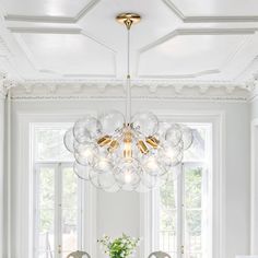 a dining room table with chairs and a chandelier hanging from it's ceiling